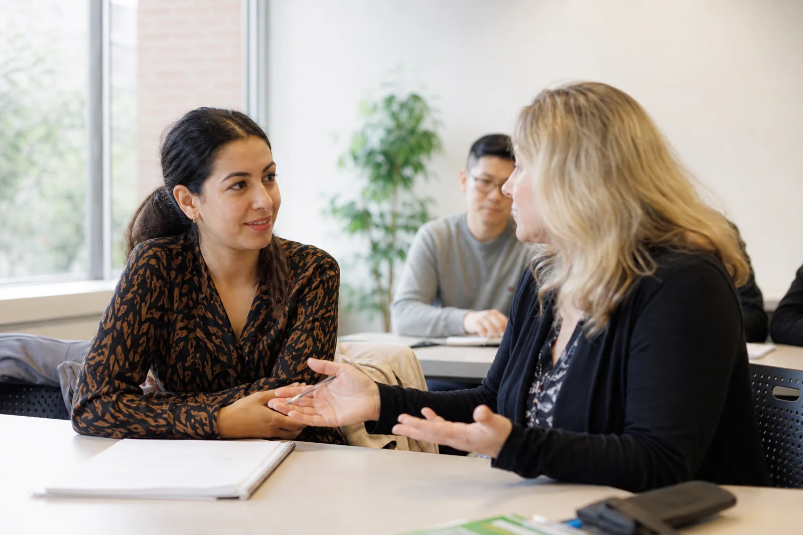 A newcomer speaking with an instructor in a learning centre